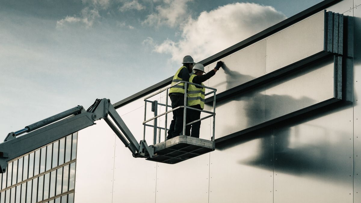 Insulated metal wall panels going up from the boom lift