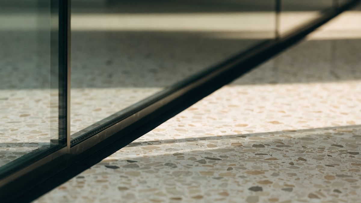Curtain wall base meeting the new terrazzo floor